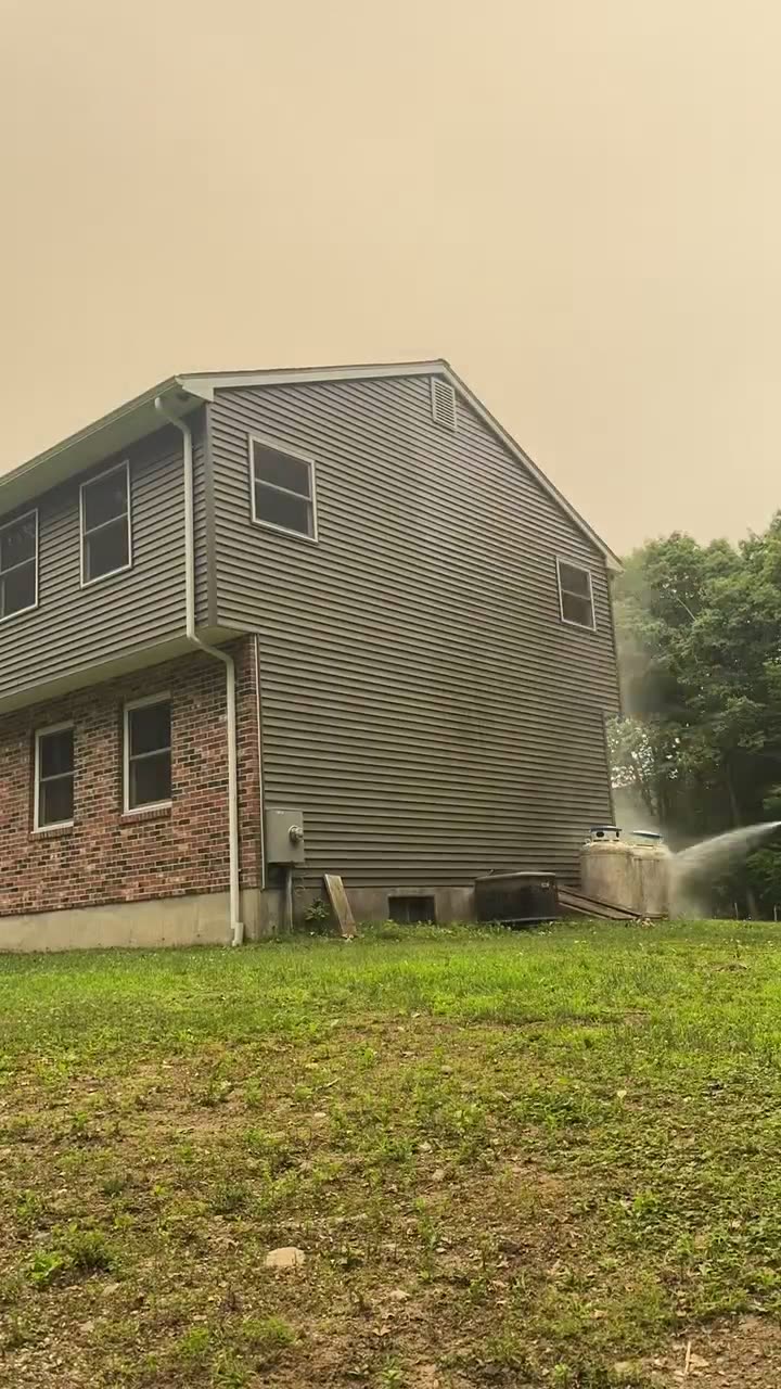 Soft washing the siding of a two-story Connecticut home