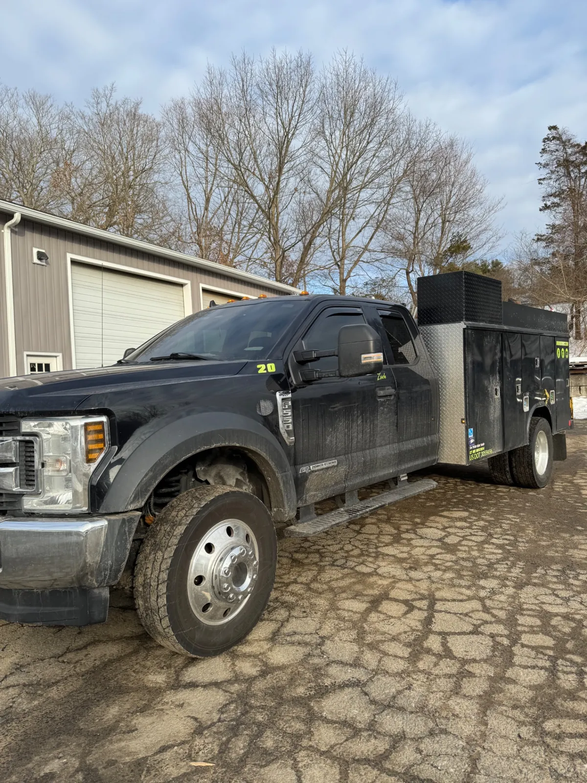 Black utility truck with winter road film before cleaning