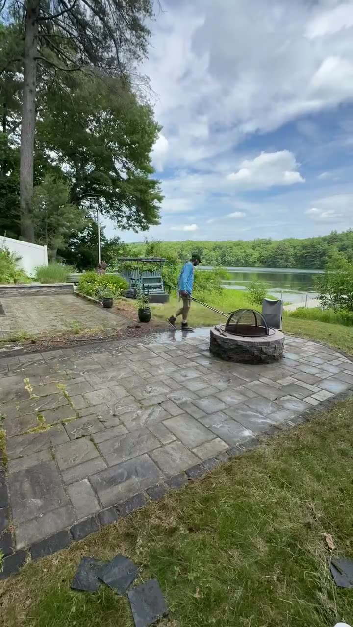 Cayne's Power Washing deep cleaning a lakeside paver patio in Connecticut